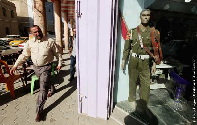 A man walks past a shop that sells uniforms to members of Iraqs military and police forces