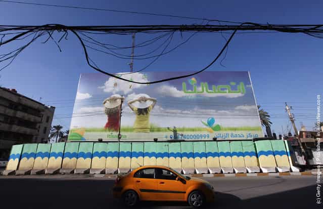 An advertisement for mobile telephone service is seen behind painted protective blast walls