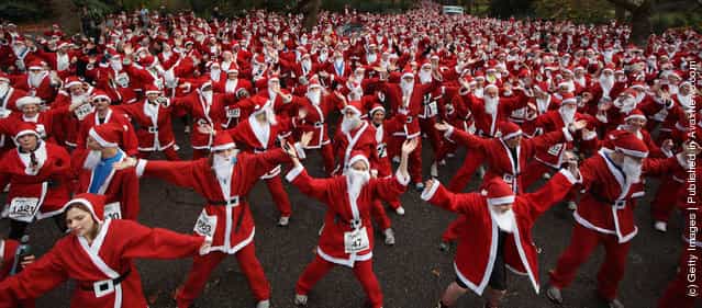 Charity runners dressed as Santa Claus warm up before taking part in the Disability Snowport UK fun run in Battersea Park
