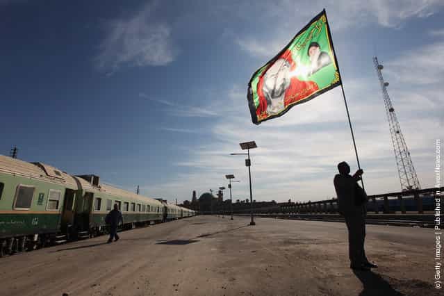 Station master Jawad Khathem prepares to mount a Shi'ite flag on a pole at Baghdad Central Railway Station in preparation for the festival Ashura