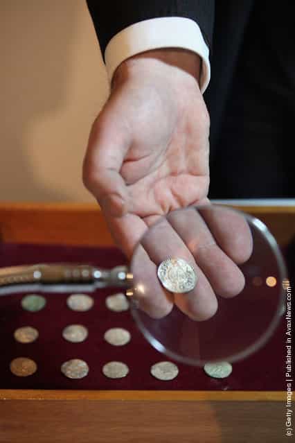 An employee of the British Museum examines a silver coin dating from 900 AD which is part of the Silverdale Viking Hoard