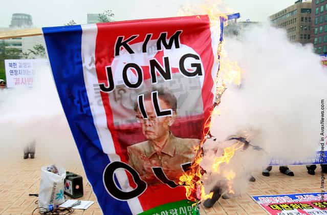 South Korean protestors burn portraits of North Korean leader Kim Jong-Il and North Korean flag during a anti-North Korea rally at the National Assembly