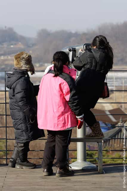Tourists use binoculars to look over the North Korea at the Imjingak observation post