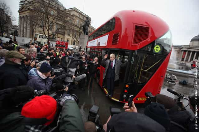 London Mayor Boris Johnson waves from a new prototype red double decker bus in Trafalgar Square