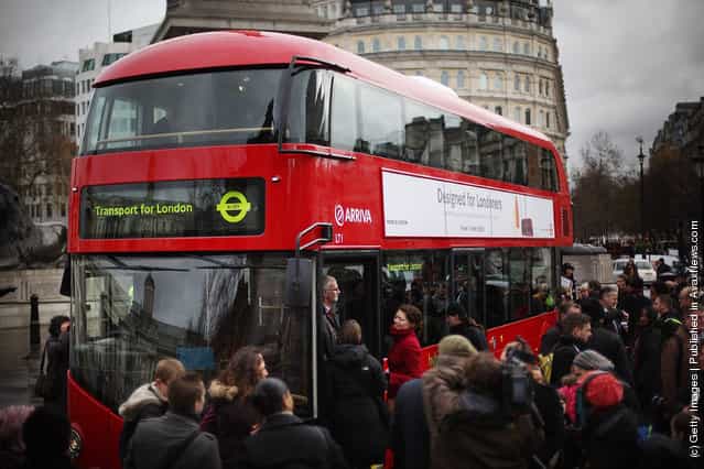 Reporters and television crews surround a new prototype red double decker bus in Trafalgar Square