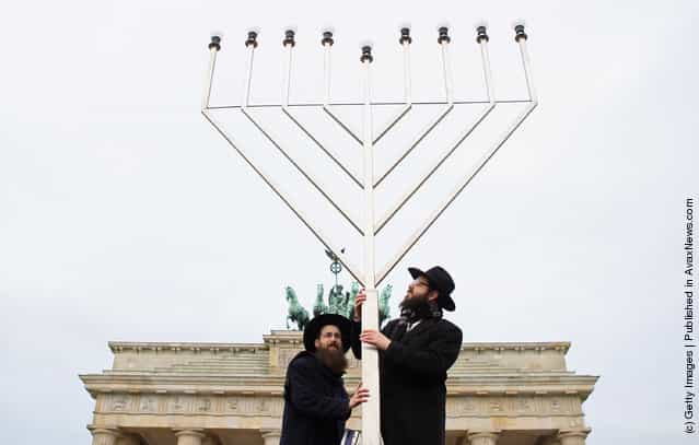 Rabbis Yehuda Teichtal (L) and Schmuel Segal pray as they erect a large nine-armed candleholder, a Hannoukiah, or Menorah, ahead of the start of the eight-day-long and annual Jewish Festival of Lights known as Chanukah, in front of the Brandenburg Gate