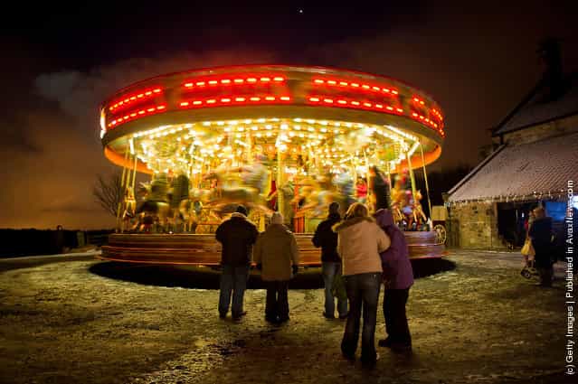 Parents watch their children ride a merry-go-round at Beamish, the living museum of the North