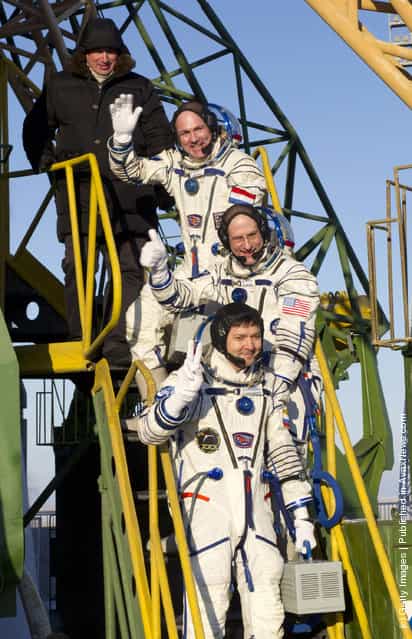 ESA Russian cosmonaut Oleg Kononenko, NASA astronaut Don Pettit and ESA astronaut Andre Kuipers wave goodbye to the crowd gathered at the foot of the Soyuz launch pad stairs before taking the elevator to the top of the Soyuz rocket