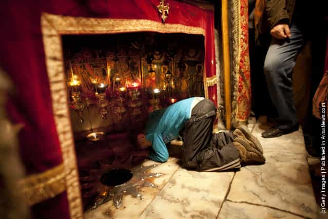 A Christian boy prays at the Grotto in the Church of the Nativity
