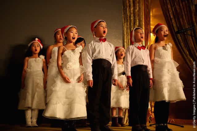 Chinese children sing Christmas songs for customers at a shopping center on Christmas Eve