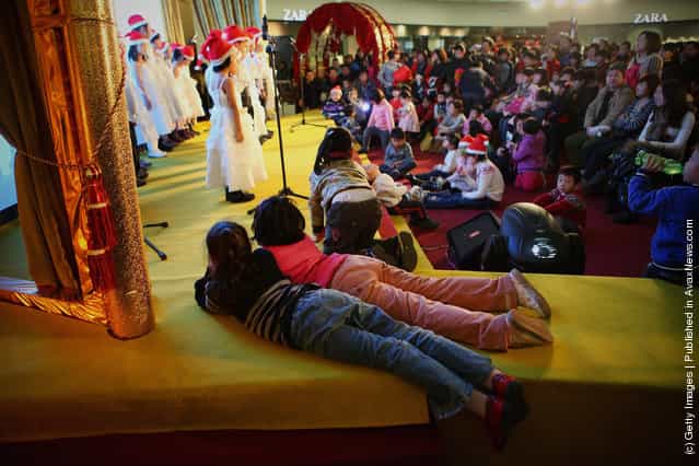 Chinese children sing Christmas songs for customers at a shopping center on Christmas Eve