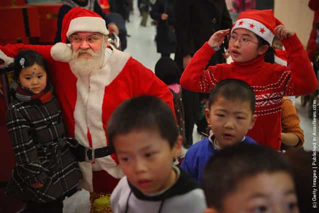 Santa stays with Chinese children at a shopping center on Christmas Eve