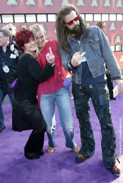 The Osbournes star Sharon Osbourne (L) and musician, Rob Zombie, flip the finger as Zombies wife looks on at the 2002 MTV Movie Awards at The Shrine Auditorium