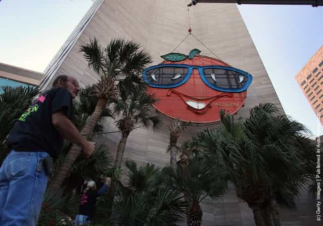 Bill Flaherty from Mr. Neon inc. helps place the Big Orange New Years time ball onto the side of the Hotel InterContinental on December 28, 2011 in Miami, Florida. The 35-foot ball rises 400 feet to the top of the building and is lowered at midnight on the 31st to mark the beginning of the New Year in Miami