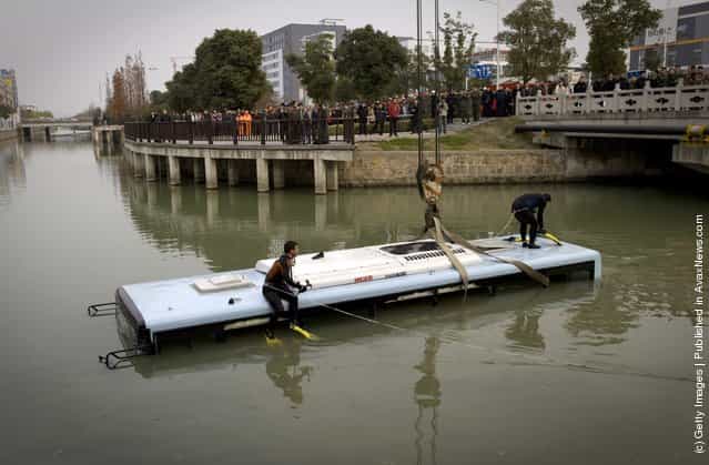 Workers prepare to salvage a bus on December 29, 2011 in Suzhou, China. A bus carrying eight people collided with a car on a bridge and crashed into river on Thursday afternoon, injuring all aboard