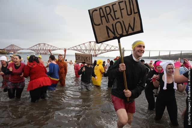 New Year revellers, many in fancy dress, braved freezing conditions in the River Forth in front of the Forth Rail Bridge during the annual Loony Dook Swim