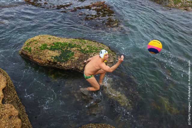 Rob Maitland of Australia collects a ball from the ocean during warm-up for the Water Polo by the Sea match between Australia and the United States of America at at Bondi Icebergs on Bondi Beach