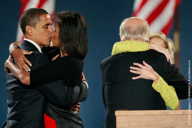 U.S. President elect Barack Obama (L) kisses his wife Michelle as Vice-President elect Joe Biden (right) embraces his wife Jill