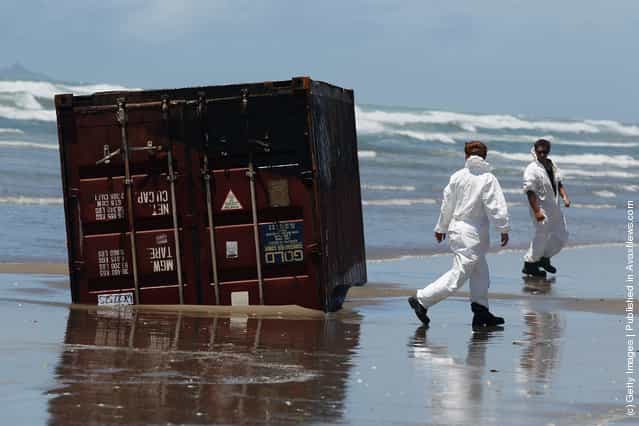 Residents check washed up containers at Waihi Beach in Tauranga, New Zealand