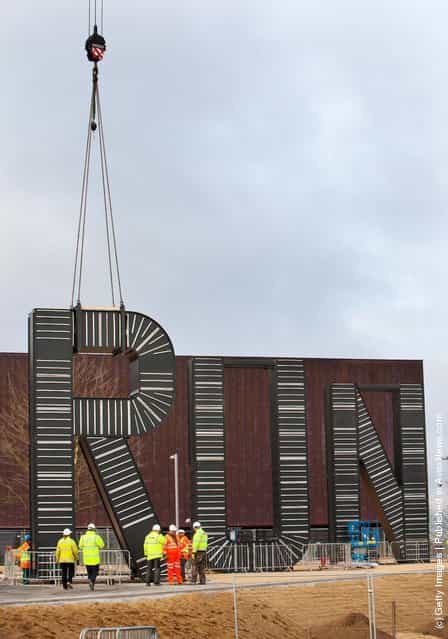 Workers carryout the installation of artist Monica Bonvicinis RUN sculpture in the plaza of the London 2012 Handball Arena at the Olympic Park
