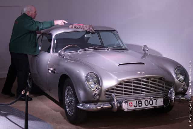 A member of the musuem team attends to a Aston Martin DB5 used in the James Bond film Goldfinger and being displayed at the Bond In Motion exhibition