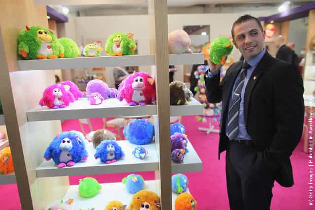 A sales representative listens to the noises made by a Monstaz toy on display at the 2012 London Toy Fair