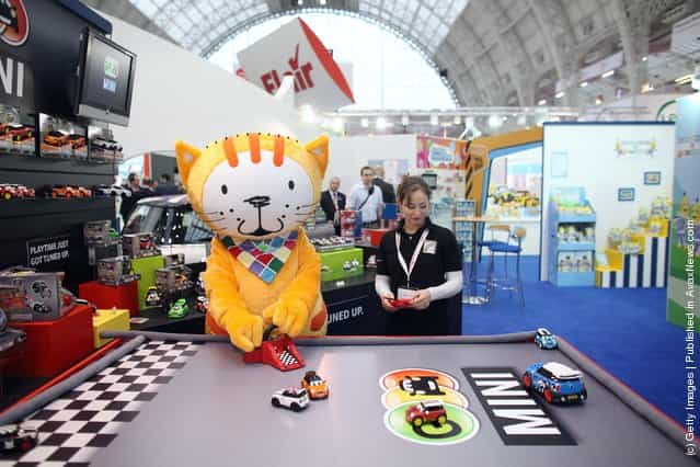 sales representative and toy character play with radio-controlled cars on display at the 2012 London Toy Fair