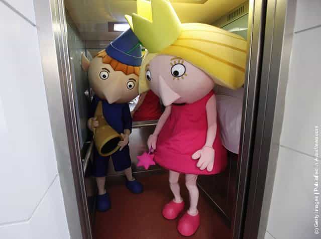 People dressesd as toys Ben and Holly use a lift at the 2012 London Toy Fair