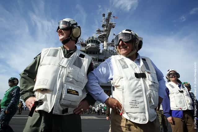 U.S. Secretary of Defense Leon E. Panetta (R), escorted by Commander of Strike Group Twelve Rear Admiral Walter E. Carter, Jr. (L), watches day flight operations from the flight deck of the aircraft carrier USS Enterprise