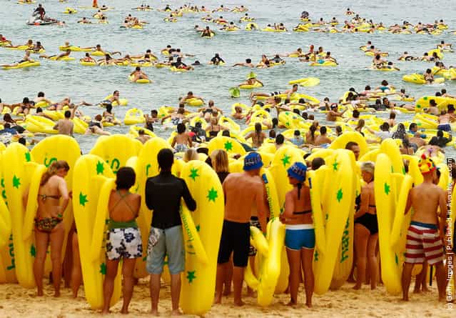Beachgoers ride the surf on inflatable thongs ahead of the annual Havaianas Thong Challenge World Record attempt as Australia celebrates Australia Day at Bondi Beach