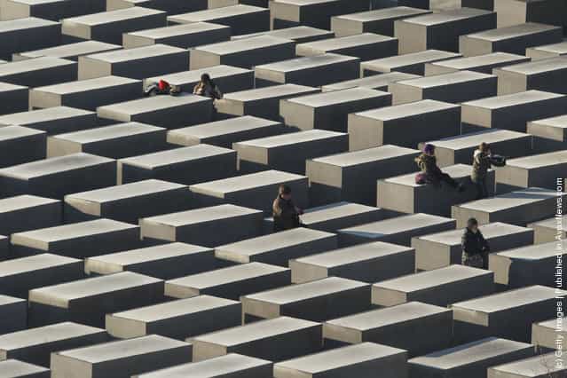 Visitors walk among stellae at the Memorial to the Murdered Jews of Europe, also called the Holocaust Memorial