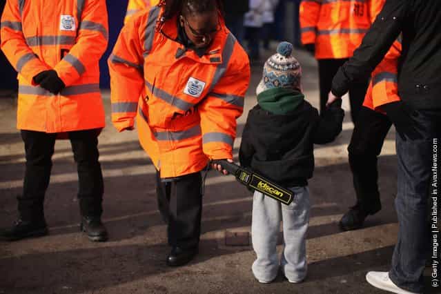 A young Queens Park Rangers fan is searched with metal detector before entering the family stand at the Loftus Road stadium