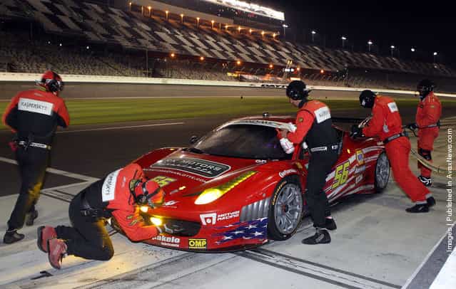 The #56 AF - Waltrip - Ferrari 458, driven by Robert Kauffman; Michael Waltrip; Travis Pastrana; Rui Aguas, pits in the early morning hours during the Rolex 24