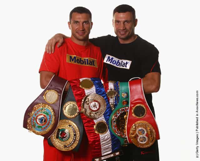 Wladimir Klitschko (L) and his brother Vitali Klitschko pose with their championship belts including the WBO Super World Champion belt, 'THE RING' Magazine belt, WBC belt und IBF belt during a photocall at Hotel Stangwirt