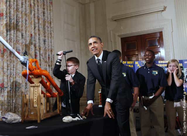 President Barack Obama watches as Joey Hudy (L), 14, from Phoenix, Arizona pumps the Extreme Marshmallow Cannon he invented, while touring student science fair projects on exhibit in the State Dining Room at the White House