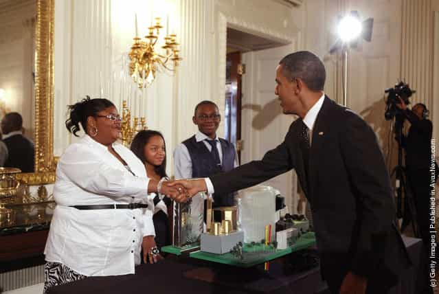 U.S. President Barack Obama (R) greets Jayla Mae Dogan, Ashley Cassie Thomas, and Lucas Cain Beal, all 13, of Detroit, Michigan, who are part of a team who focused on designing a city around the theme of Fuel Your Future: Imagine New Ways to Meet Our Energy Needs and Maintain a Healthy Planet, while touring student science fair projects on exhibit in the State Dining Room at the White House
