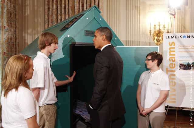 President Barack Obama (2R) discusses a lightweight portable disaster relief shelter designed by Jessica DEsposito (R), Colton Newton (2L) and Anna Woolery from Petersburg, Indiana, representing the Pike Central High School InvenTeam, while touring student science fair projects on exhibit in the State Dining Room at the White House