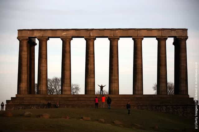Tourists have their photographs taken at the Acropolis on Calton Hill in Edinburgh, Scotland