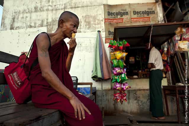 A Burmese monk eats an ice cream cone