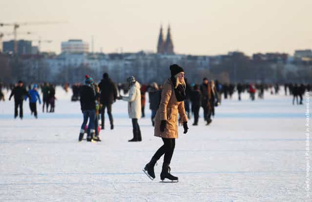 People stay on the frozen Aussenalster river during the Alstervergnuegen on February