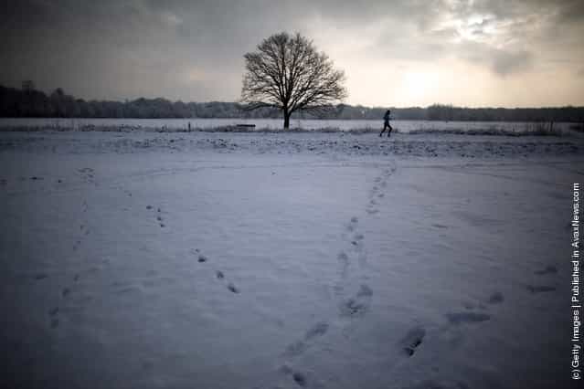 A woman jogs through the snow on Wimbledon common on February