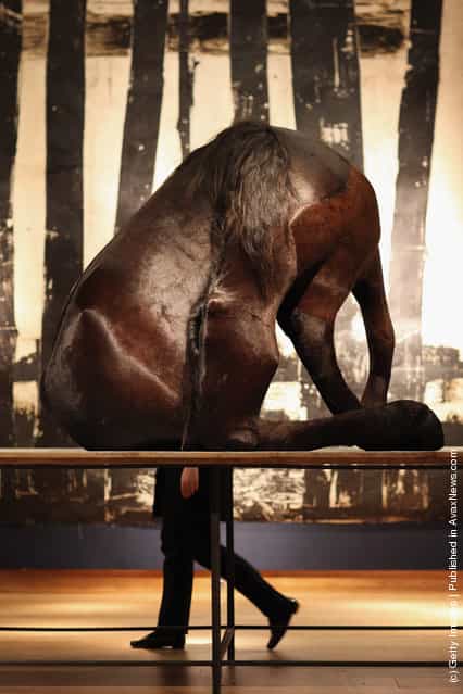 A Christie's auction house employee walks past a piece of work entitled 'The Black Horse' by Berlinde De Bruyckere
