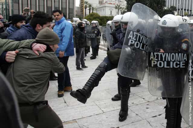 The police clash with protestors during a demonstration involving thousands of Greek civilians