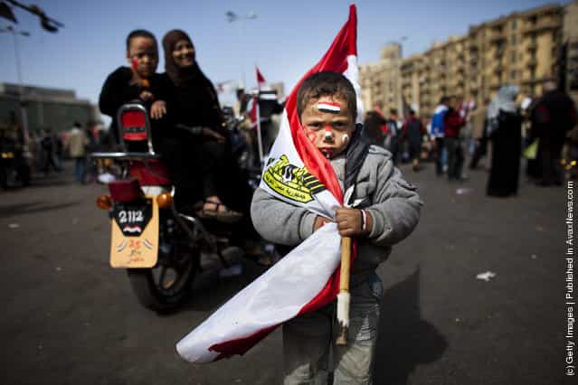 An egyptian boy wears a egyprian national flag at Tharir Square