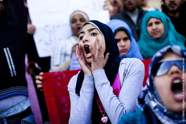 Female students shout slogans in front of the Cairo University during a protest against the military rulers of the country