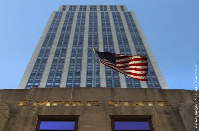 A flag blows in the wind in front of the Empire State Building