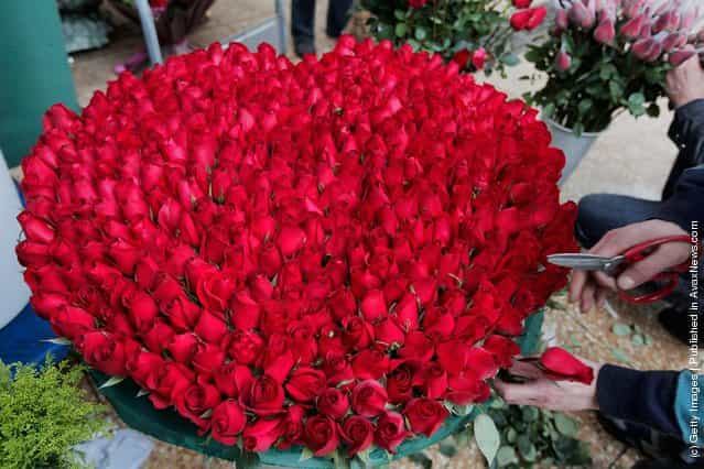 An employee arranges roses at a flower shop on Valentines Day