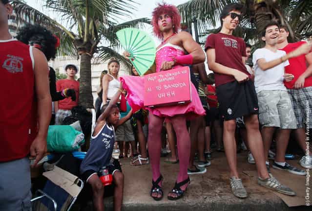 A boy lifts a Brazilian revelers skirt during Carnival celebrations along Ipanema beach in Rio de Janiero