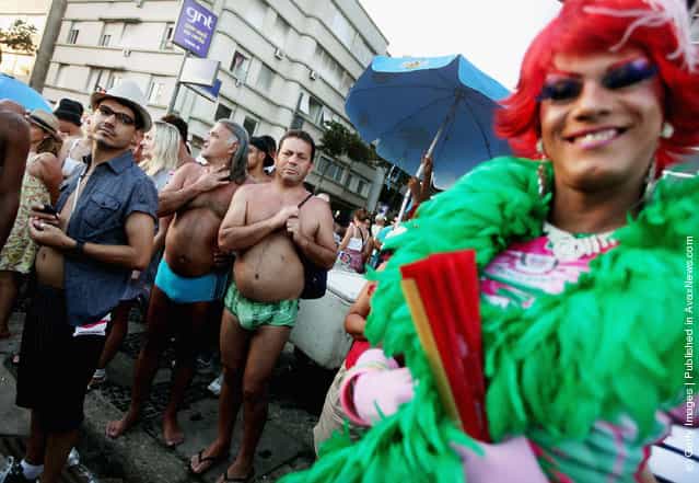 Brazilian revelers watch Carnival celebrations along Ipanema beach in Rio de Janiero