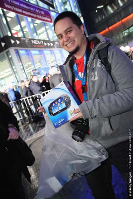 A young man shows off his new Sony PlayStation Vita portable gaming device that he just bought at the Sony Store during the official German launch of the new Vita